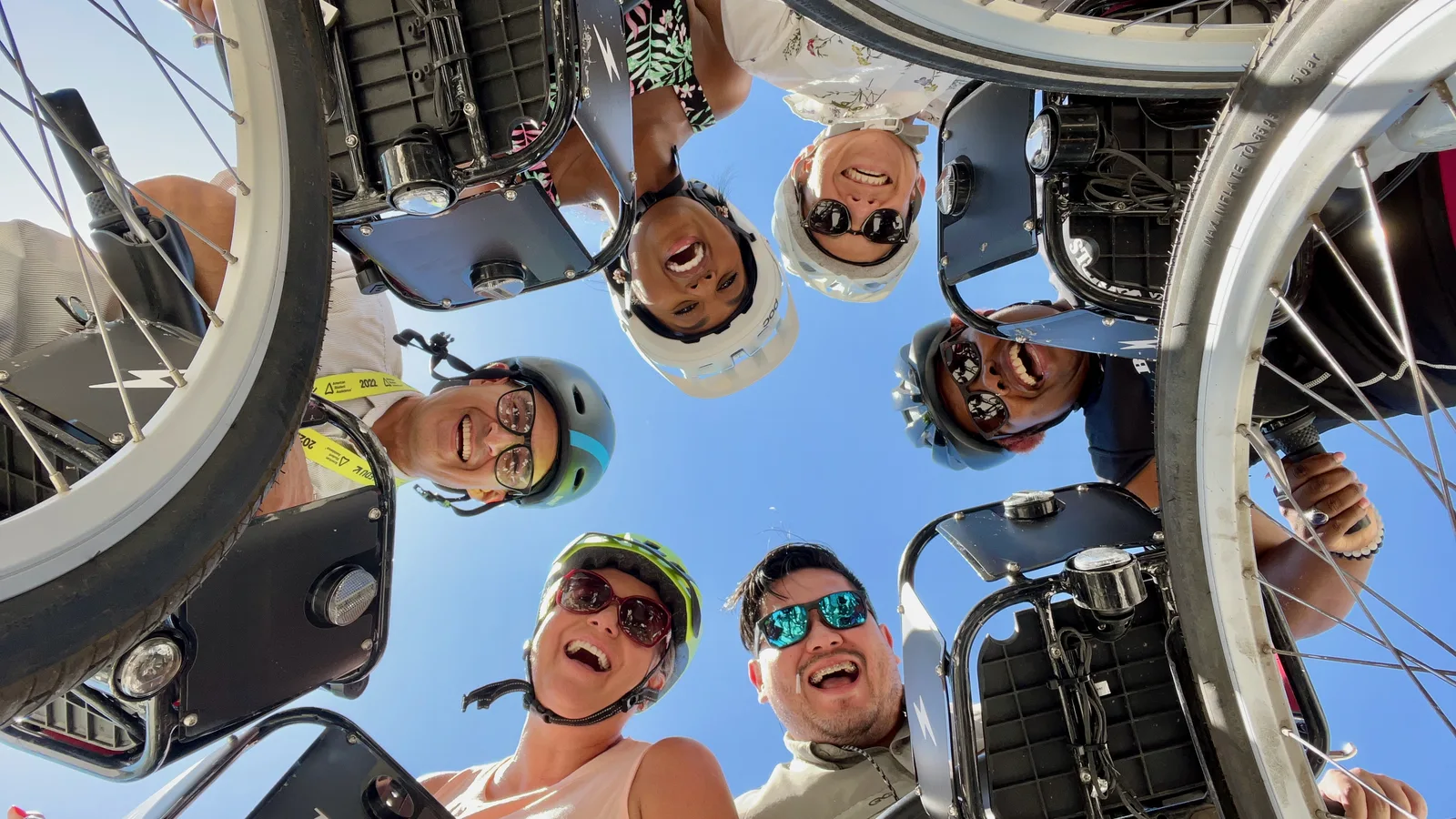 group photo of riders looking down at the camera with their bike share bicycles