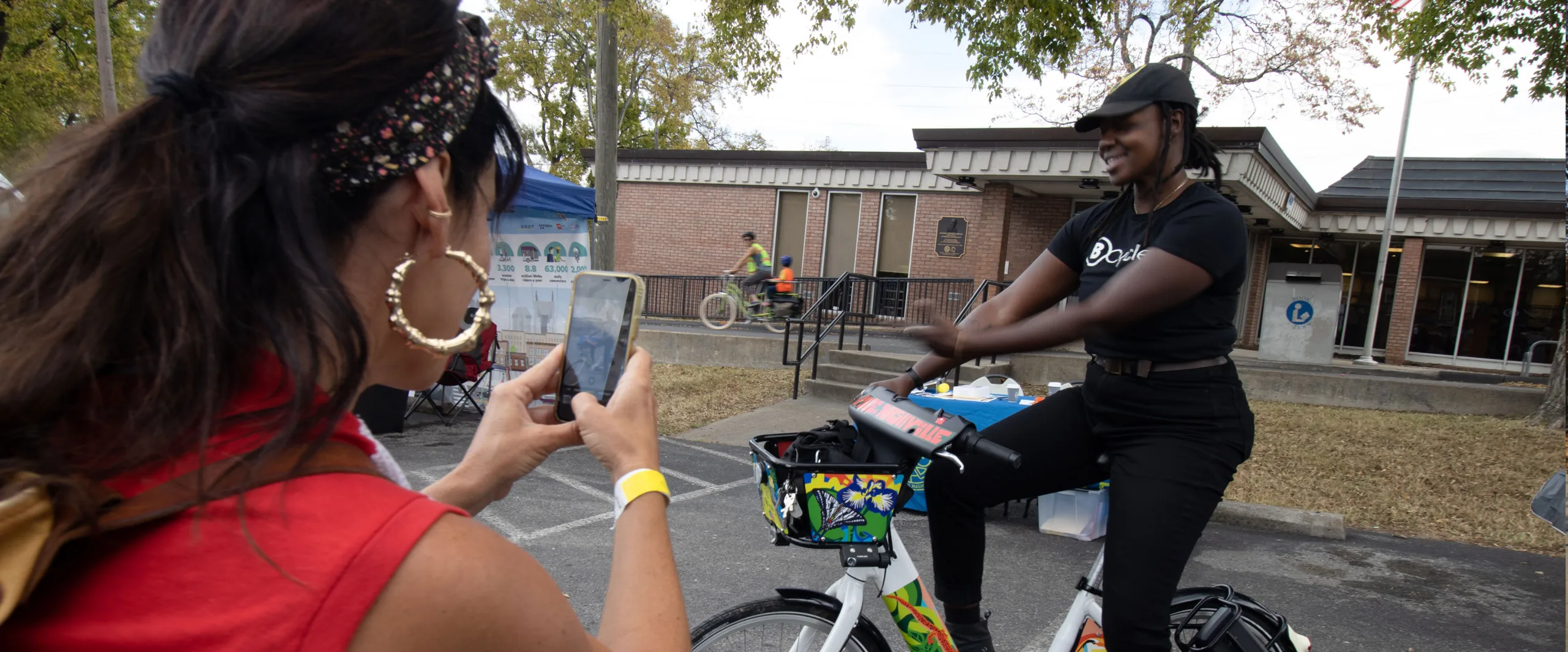 two girls taking a photo with a bike share bicycle infront of a Nashville Public Library