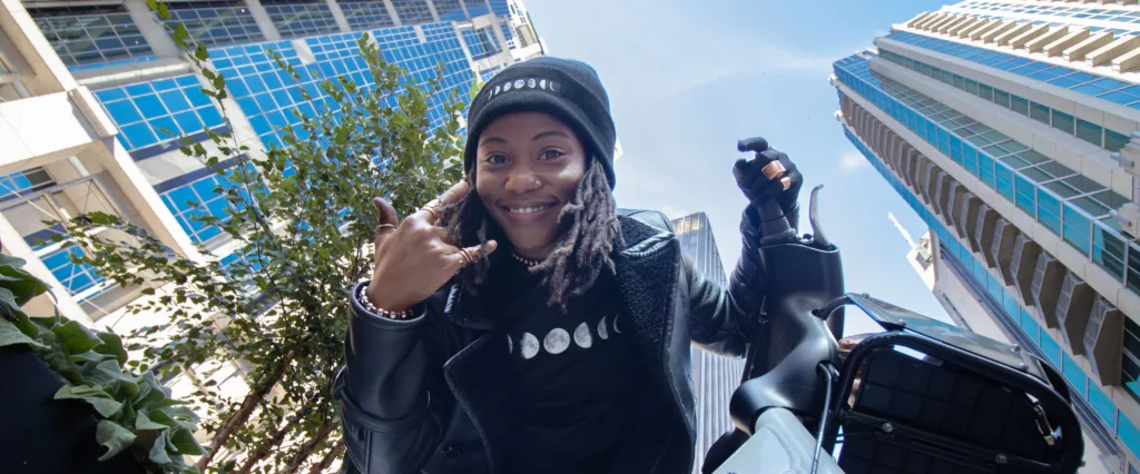 Photo of woman riding a bike share bicycle looking down at the camera in downtown Nashville