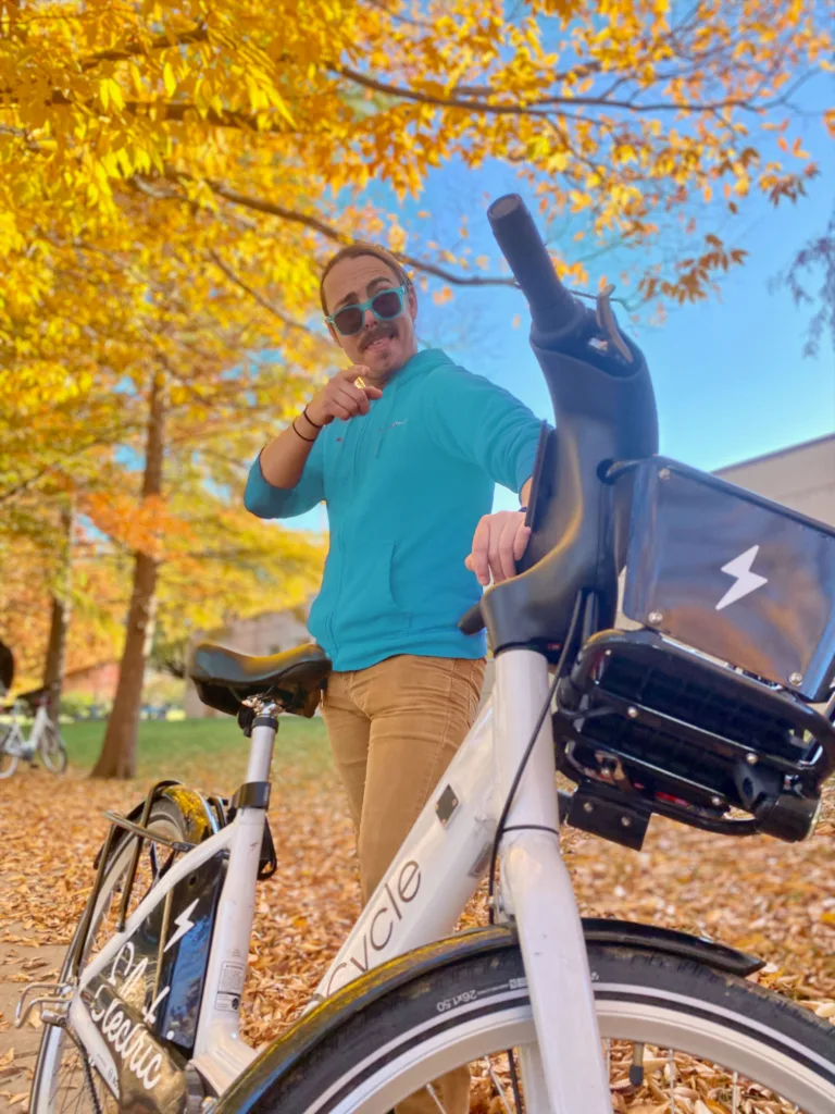 Photo of male rider with a bike share bicycle pointing to the camera